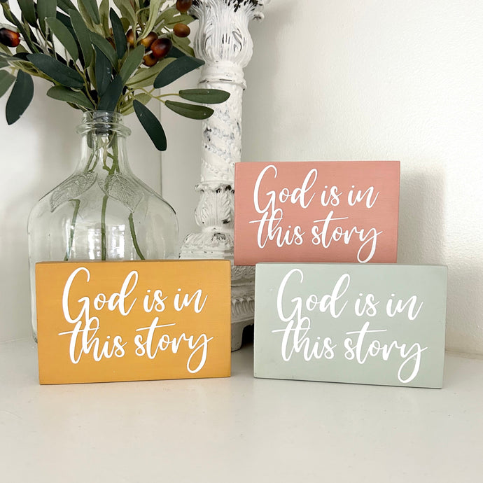 Mini Wooden Sign in Various Colors with the painted words God Is In This Story